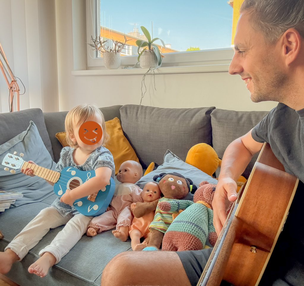 Michael Holzmayer mit seiner Tochter beim Musizieren mit einer Gitarre.