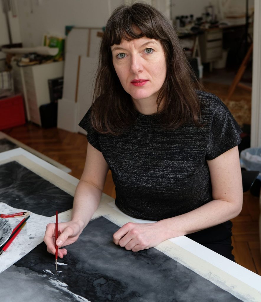 Alexandra Kontriner in ihrem Atelier beim Arbeiten. Auf ihrem SChreibtisch liegen unterschiedlicheste Utensilien, wie Bleistifte.