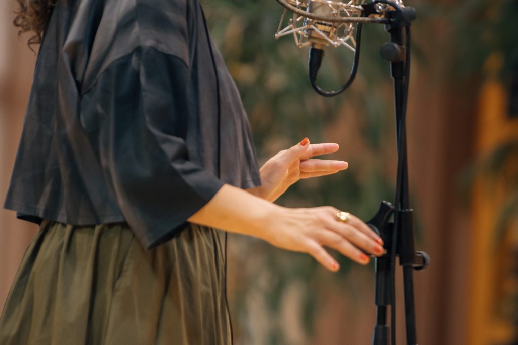 Ein Halbporträt von Júlia Kozáková im Studio vor dem Mikorfon. | © Jiří Lubojacký