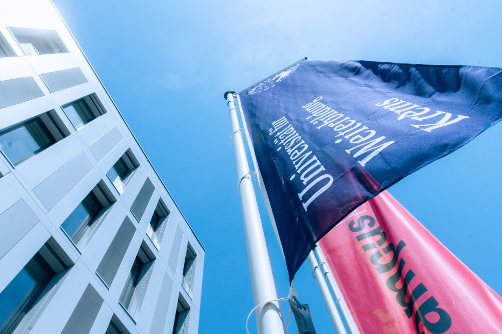 Foto des Campus Krems. Zu sehen ist die Flagge und ein Gebäudeteil der Universität für Weiterbildung Krems. | © Walter Skokanitsch